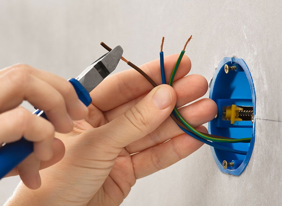 Techniker entfernt die Isolierung an elektrischen Kabeln mit einem Saitenschneider